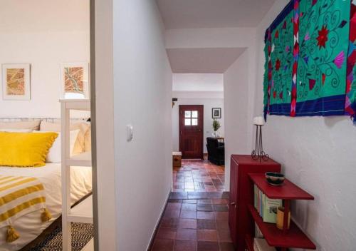a bedroom with a bed and a room with a staircase at Casa do Largo in Torres Vedras