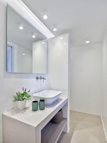 a white bathroom with a sink and a mirror at Villa Sol Este Naousa Paros in Naousa