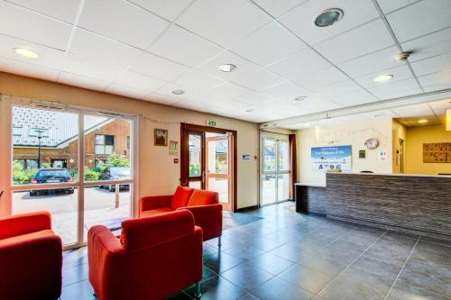 a waiting room with red chairs and a fireplace at Studio 2 Personnes MAE-9161 in La Féclaz