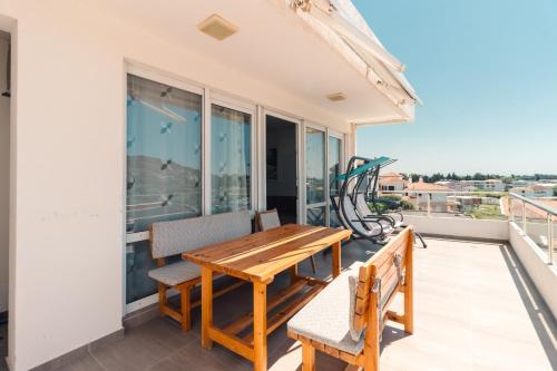 a balcony with a wooden table and chairs at Apartments FourRoses in Ulcinj