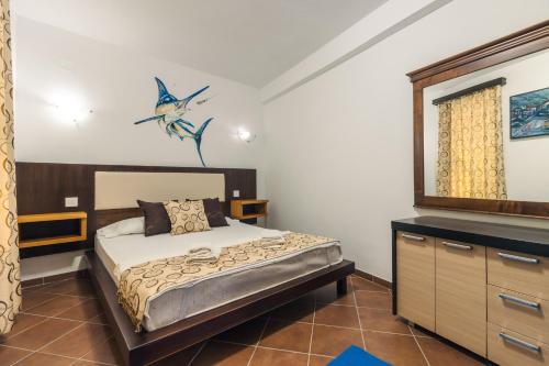 a bedroom with a bed and a dresser and a mirror at Apartments FourRoses in Ulcinj