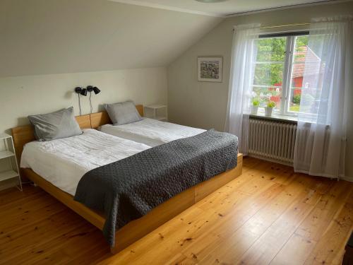 a bedroom with a large bed and a window at Skirsnäs gård in Växjö