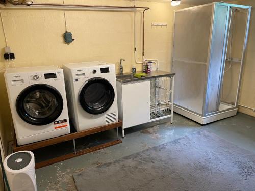 a laundry room with a washing machine and a refrigerator at Skirsnäs gård in Växjö