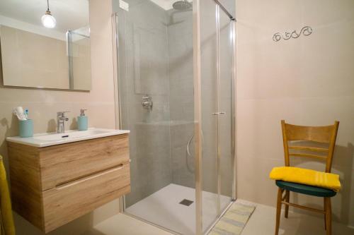 a bathroom with a shower and a sink and a chair at Colibrì in Salò