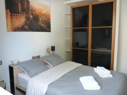 une chambre avec un lit avec deux serviettes dessus dans l'établissement Maison L'Ollivia - Terrasse - Parking gratuit, à Carcassonne