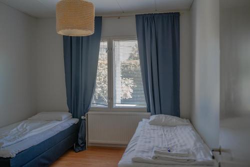 a bedroom with two beds in front of a window at West Coast Hideaway in Pietarsaari