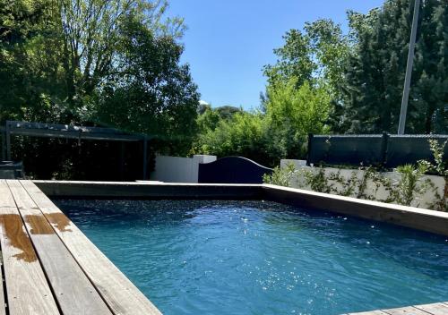 - une piscine dans une cour avec une terrasse en bois dans l'établissement Villa moderne, proche du centre, à Aix-en-Provence