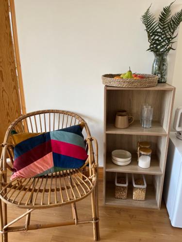 a chair with a colorful pillow sitting next to a shelf at Greenview House in Clones