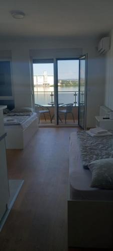 a room with two beds and a view of the water at Apartmani Casper in Kladovo