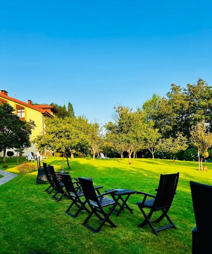a row of lawn chairs sitting in the grass at Apartamentos Rurales L'Arquera in Llanes