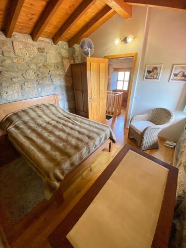 a bedroom with a bed and a stone wall at Casa da iapa in Soajo