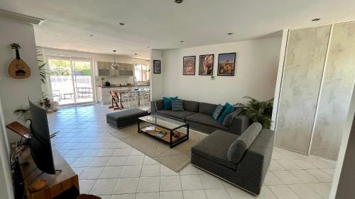 un salon avec un canapé et une table dans l'établissement Villa Pura Vida - 6 personnes - piscine, jaccuzi et cuisine d'été, à Velaux