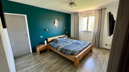une chambre avec un lit et un mur bleu dans l'établissement Villa Pura Vida - 6 personnes - piscine, jaccuzi et cuisine d'été, à Velaux