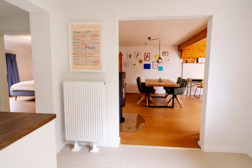 a room with a white radiator and a dining room at birds-nest Ferienwohnung Balkon Kaminofen in Darstein