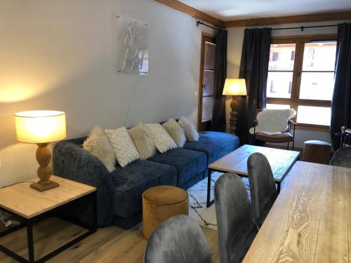 un salon avec un canapé bleu et une table dans l'établissement Chalet Alouette, 3 bed, Arc 1950, à Arc 1950