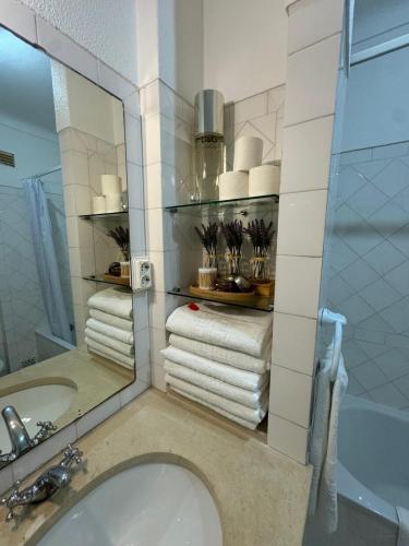 a bathroom with a sink and a mirror and towels at Villa 46 Hostel in Lagos