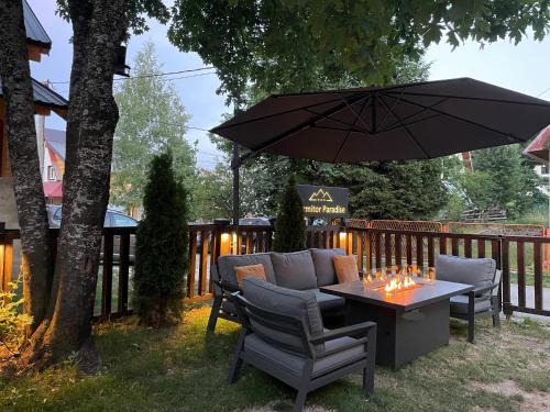 a patio with a table and chairs and an umbrella at Guest House Durmitor Paradise in Žabljak