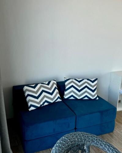 a blue couch with two pillows on it at База отдыха SUNRISE Балхаш in Balqash