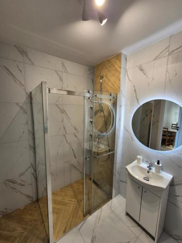 une salle de bain avec douche et lavabo dans l'établissement Apartament Sportowa przy SUNTAGO DEEPSPOT Mszczonów, à Mszczonów