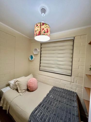 a bedroom with a bed and a lamp and a window at Hotel Boutique "PAQARI" in Vallenar