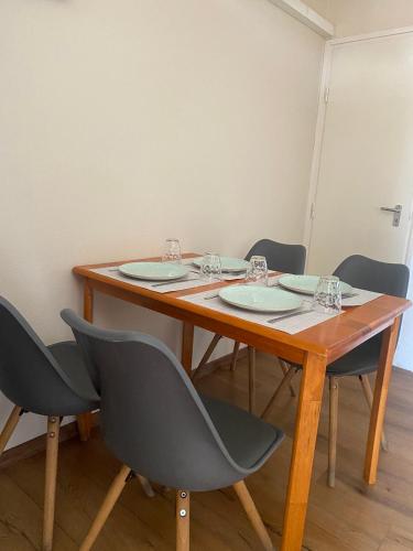 a wooden table with four chairs around it at Summer Apartments in Tiszakécske
