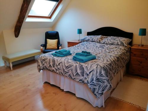 una camera da letto con un letto con asciugamani blu sopra di Rainbow Cottages a Saint-Nicolas-du-Pélem