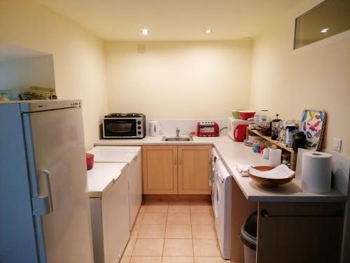 une petite cuisine avec un évier et un réfrigérateur dans l'établissement Rainbow Cottages, à Saint-Nicolas-du-Pélem