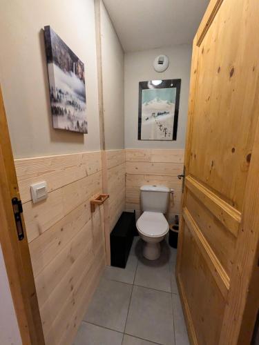 La salle de bains est pourvue de toilettes et d'un mur en bois. dans l'établissement Les Chalets Des Rennes - Appartement 4 pièces - Les Chalets Des Rennes MAE-6601, à Vars
