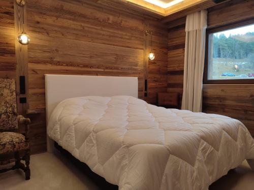 - une chambre avec un lit blanc dans une pièce dotée d'une fenêtre dans l'établissement Rooftop des Glovetes, à Villard-de-Lans