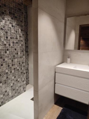 La salle de bains est pourvue d'un lavabo blanc et d'un mur. dans l'établissement Rooftop des Glovetes, à Villard-de-Lans