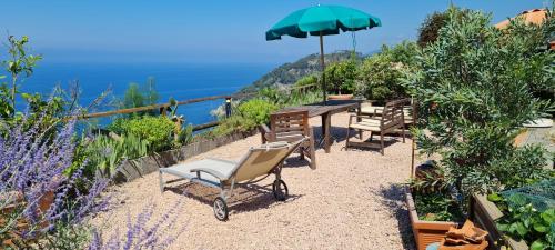 Un patio con una mesa y sillas y una sombrilla. en Cà Gialla, en Bonassola