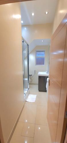 a bathroom with a shower and a toilet and a sink at London Luxury 3 bedroom flat, 2 bathrooms, Living Room, free parking, 4 mins to station, garden in Ilford