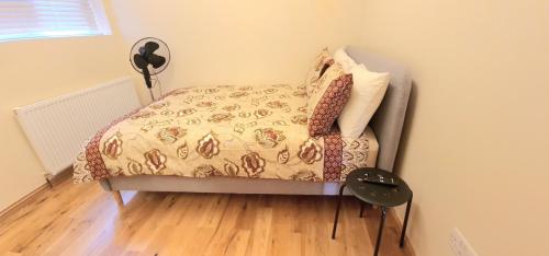 a bedroom with a bed with a comforter and pillows at London Luxury 3 bedroom flat, 2 bathrooms, Living Room, free parking, 4 mins to station, garden in Ilford