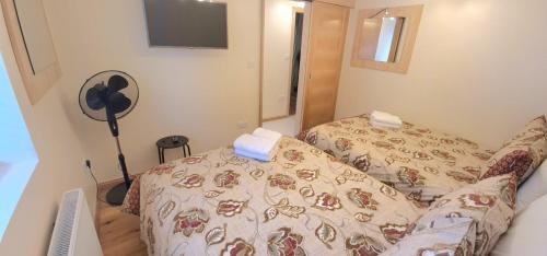 a room with a bed and a fan in it at London Luxury 3 bedroom flat, 2 bathrooms, Living Room, free parking, 4 mins to station, garden in Ilford