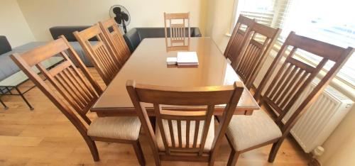 a dining table and chairs in a room at London Luxury 3 bedroom flat, 2 bathrooms, Living Room, free parking, 4 mins to station, garden in Ilford
