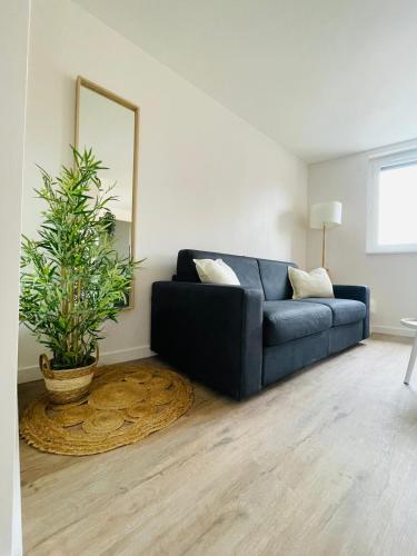 a living room with a blue couch and a plant at Verrières 1 in Issoire