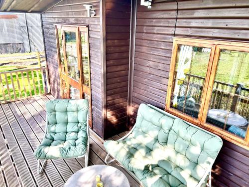 two chairs and a table on a porch at Barons Granary, The Chicken Run, Iden near Rye in Iden