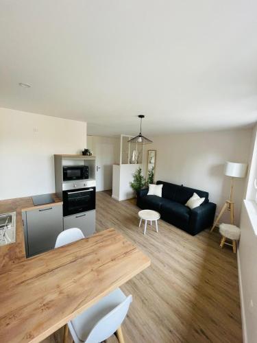 a living room with a black couch and a table at Verrières 1 in Issoire