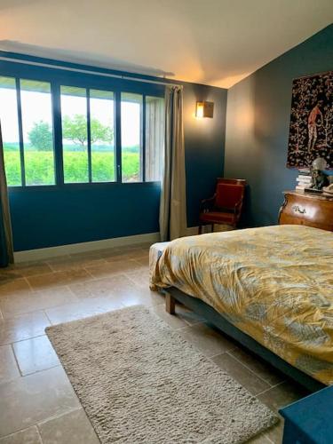 une chambre avec un lit et une grande fenêtre dans l'établissement Villa vignoble Sauternes et spa, à Sauternes