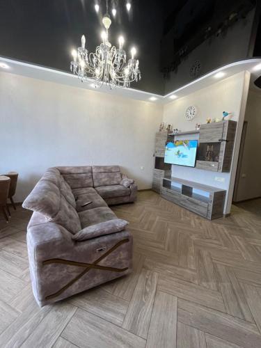 a living room with a large couch and a chandelier at ზღვის ულამაზესი ხედები in K'obulet'i