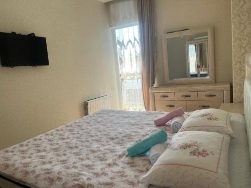 a bedroom with a bed with pillows and a mirror at ზღვის ულამაზესი ხედები in K'obulet'i