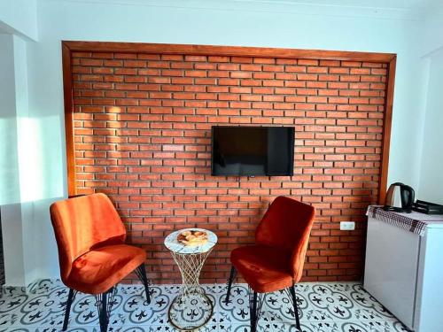 two chairs and a table in front of a brick wall at Siesta butik otel 17 in Ayvacık