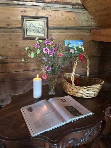 a table with a book and a candle and flowers at Rustic Beaverfoot Lodge Room N6 in Parson