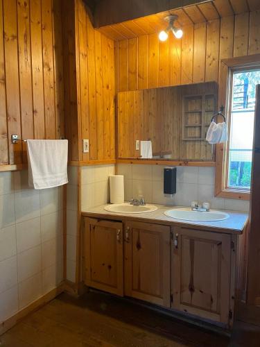 a bathroom with two sinks and a window at Rustic Beaverfoot Lodge Room N6 in Parson