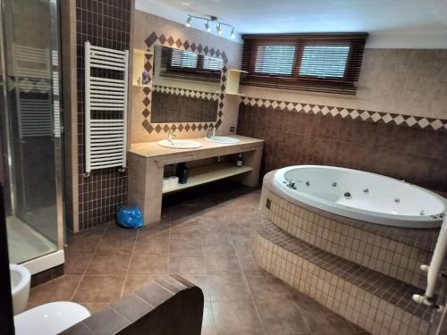 a bathroom with a tub and a sink and a mirror at DolceVita Eur2 Luxury Apartament in Rome