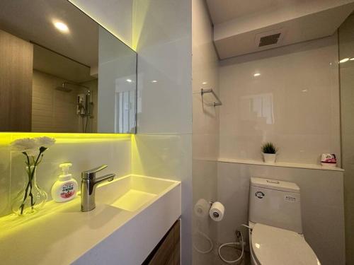 a bathroom with a sink and a toilet and a mirror at S87-7052 BTS Onnut High Floor Gym Swim Good View in Bangkok
