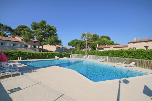 - une piscine dans une villa avec des chaises et des arbres dans l'établissement Maison dans résidence avec piscine et tennis, à Antibes