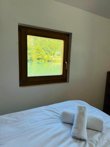 a bedroom with a window with towels on a bed at Dolce vita cottage - waterfront in Bihać
