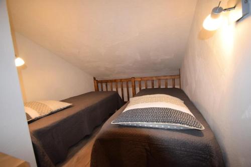 dwa łóżka pojedyncze w małym pokoju z antresolą w obiekcie Résidence Le Cervin - 3 Pièces 6 pers Duplex - WIFI- LE CERVIN - PLAGNE SOLEIL MAE-8924 w Aime La Plagne