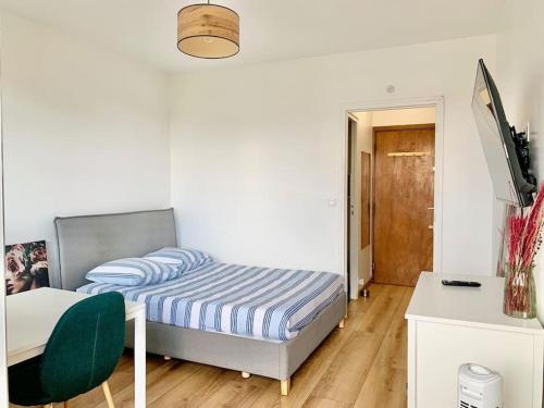 une chambre avec un lit, un bureau et une chaise dans l'établissement Cosy studio Balcon Paris Montparnasse, à Paris